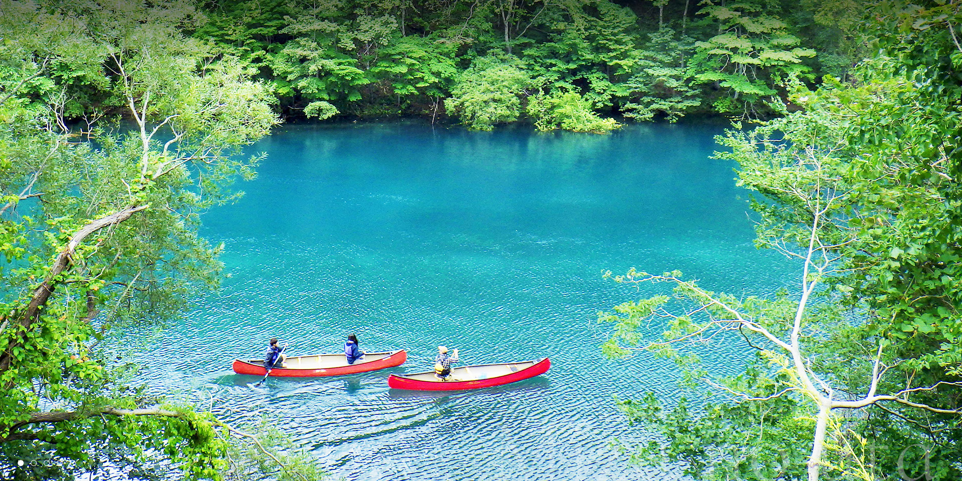 しこつ湖 鶴雅リゾートスパ 水の謌 — 千歳市・支笏湖畔 · 透明度の高い湖面にカヌー2艇が浮かぶ朝の風景