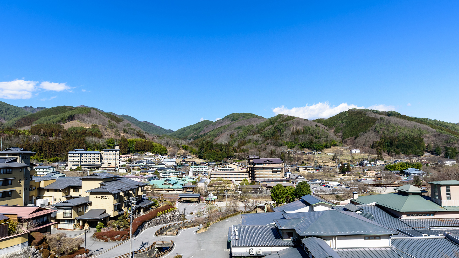 ホテルひるがみの森 — 阿智村昼神温泉・高台の客室から見下ろす温泉街と里山の稜線