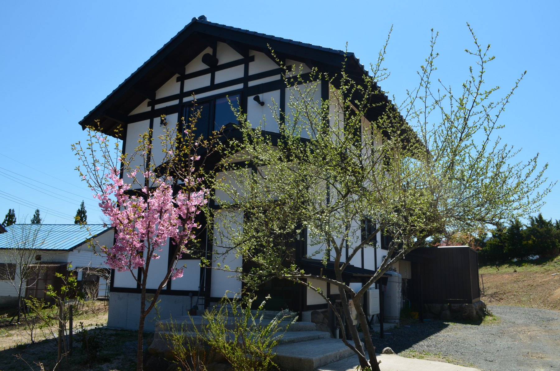 岡山ひるぜん貸別荘ピーターパン — 真庭市蒜山 · 屋根付きデッキを備えた一棟貸しのログコテージ外観