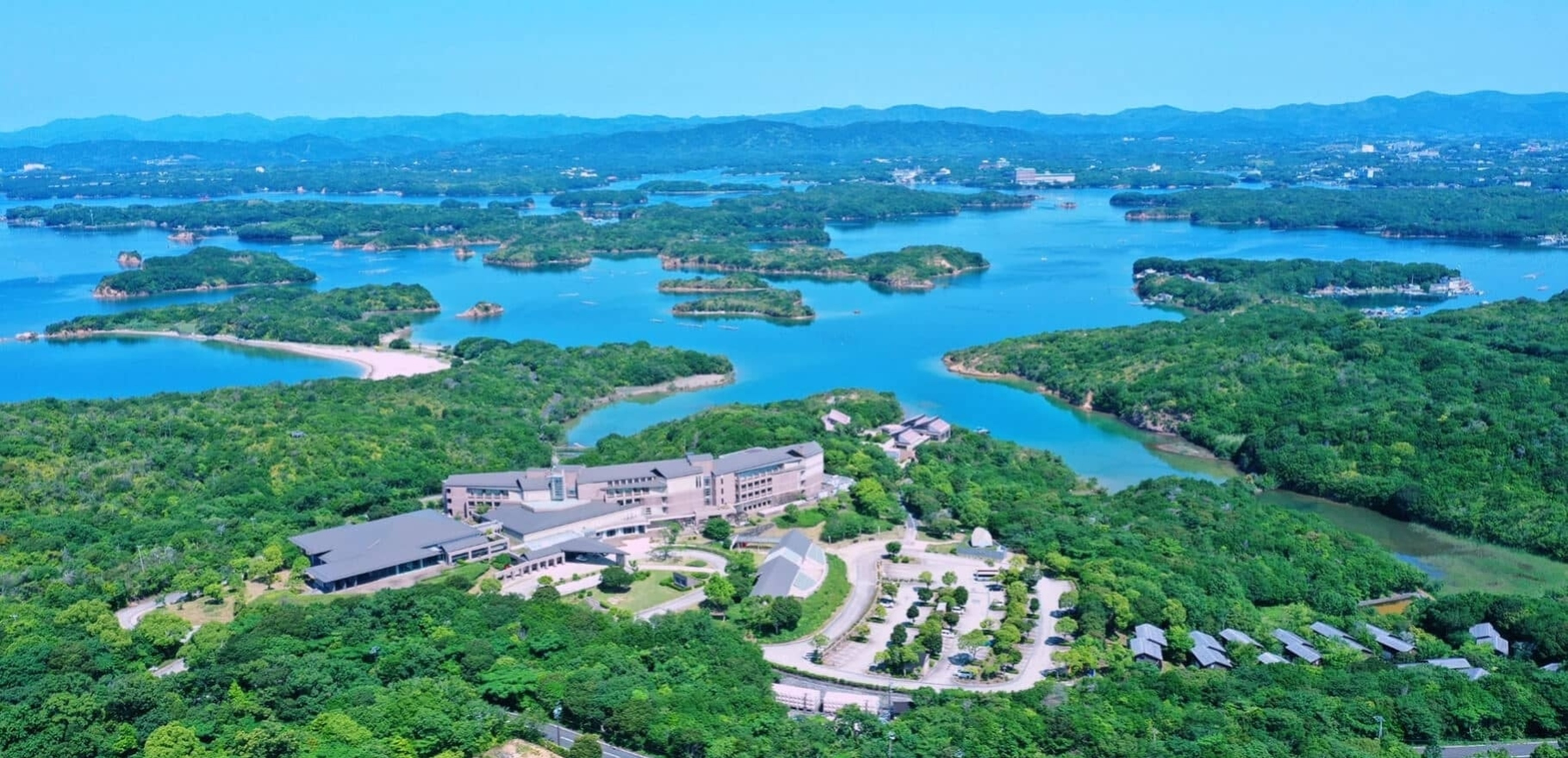 都リゾート 奥志摩 アクアフォレスト — 三重県志摩市 · 英虞湾の入り江に囲まれた本館とコテージ群の俯瞰