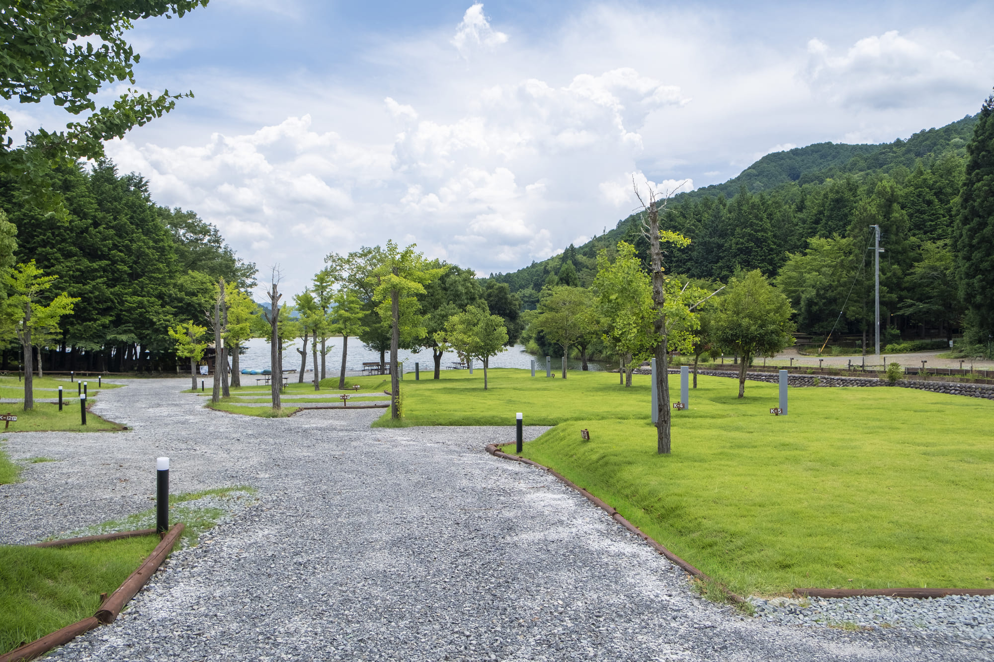 キャンプリゾート森のひととき — 兵庫・丹波市 · 湖畔に広がる芝生のキャンプフィールドと里山の稜線