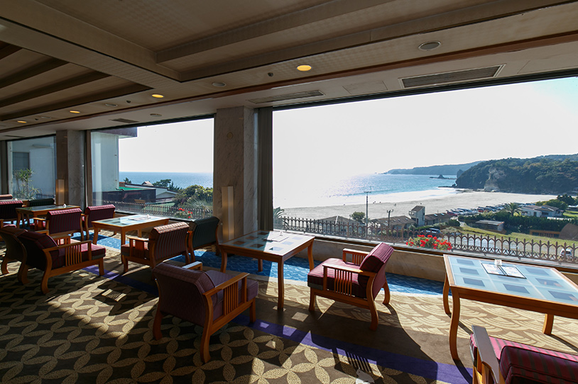 下田大和館 — 多々戸浜を望む館内ラウンジ · 弧を描く白砂の入り江と穏やかな水際