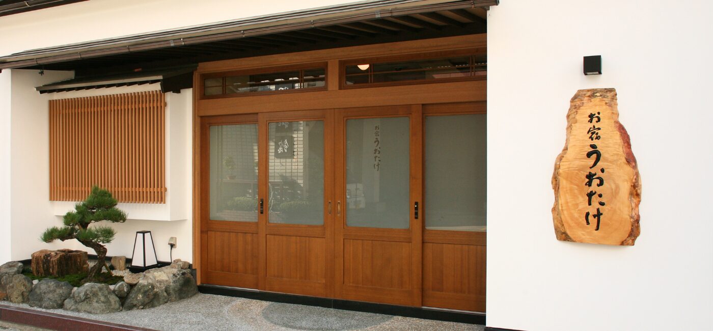 越前の宿 うおたけ — 福井県越前町厨 · 木の引き戸と一枚板の看板が迎える海辺の料理旅館の玄関