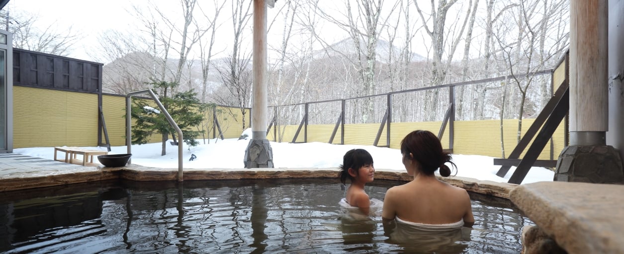 休暇村嬬恋鹿沢 — 親子で入る露天風呂「雲井の湯」。木々に囲まれた開放的なつくり