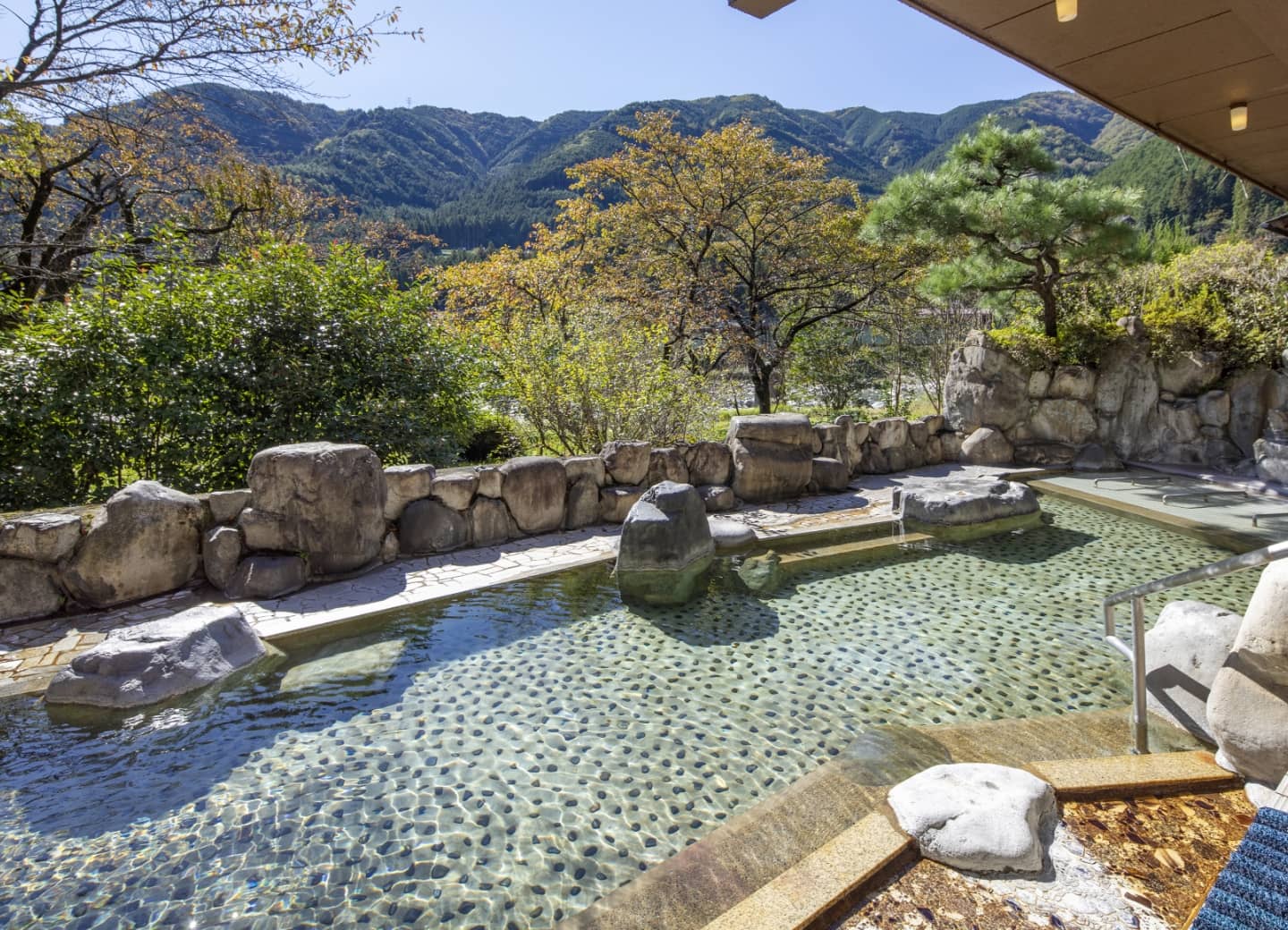 下呂温泉 望川館 — 岐阜・下呂 · 山を望む庭園の露天風呂と石組み