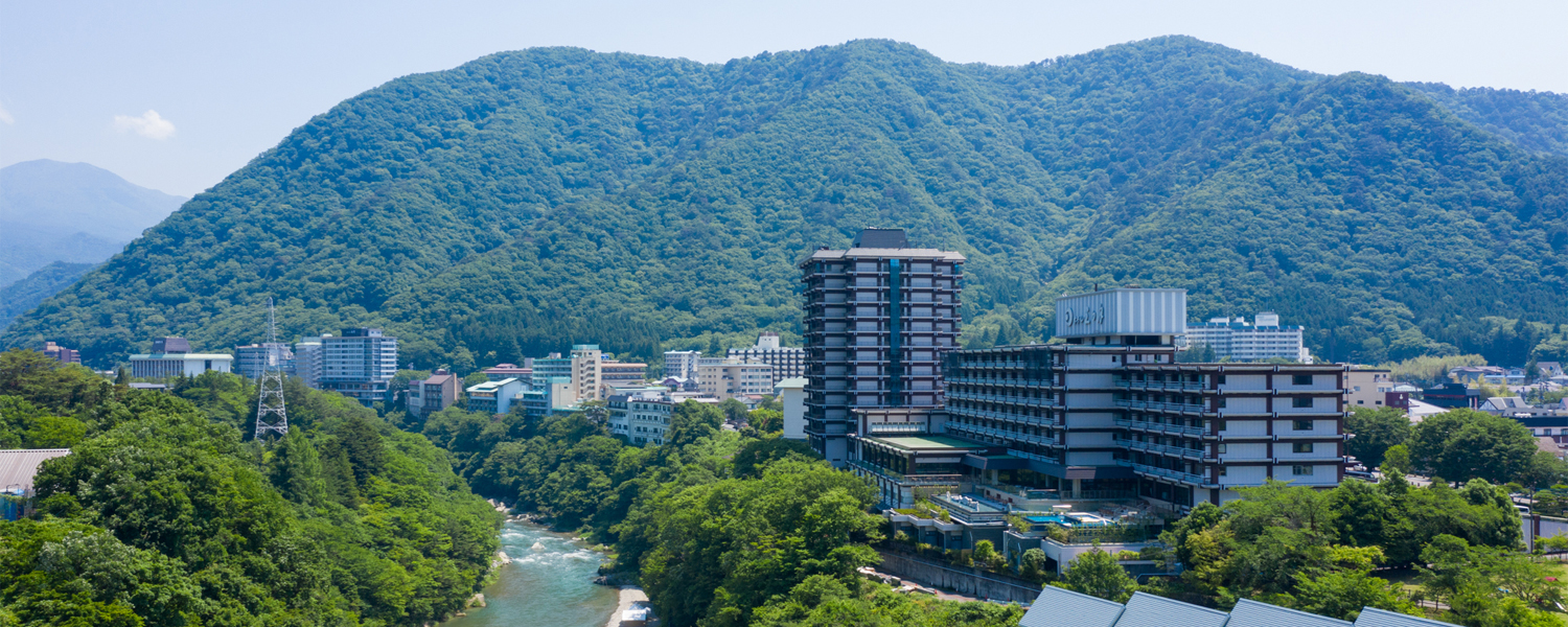 日光きぬ川ホテル三日月 — 栃木・鬼怒川 · 渓谷と山並みに面した大型温泉リゾートの外観