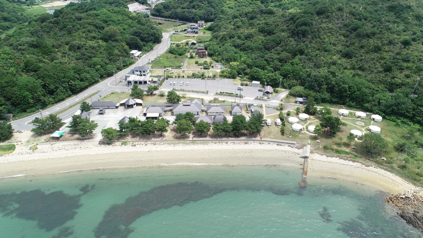 つつじ荘 — 香川県直島町・積浦海岸 · 砂浜の前に並ぶパオ(モンゴル式テント)と和室コテージ