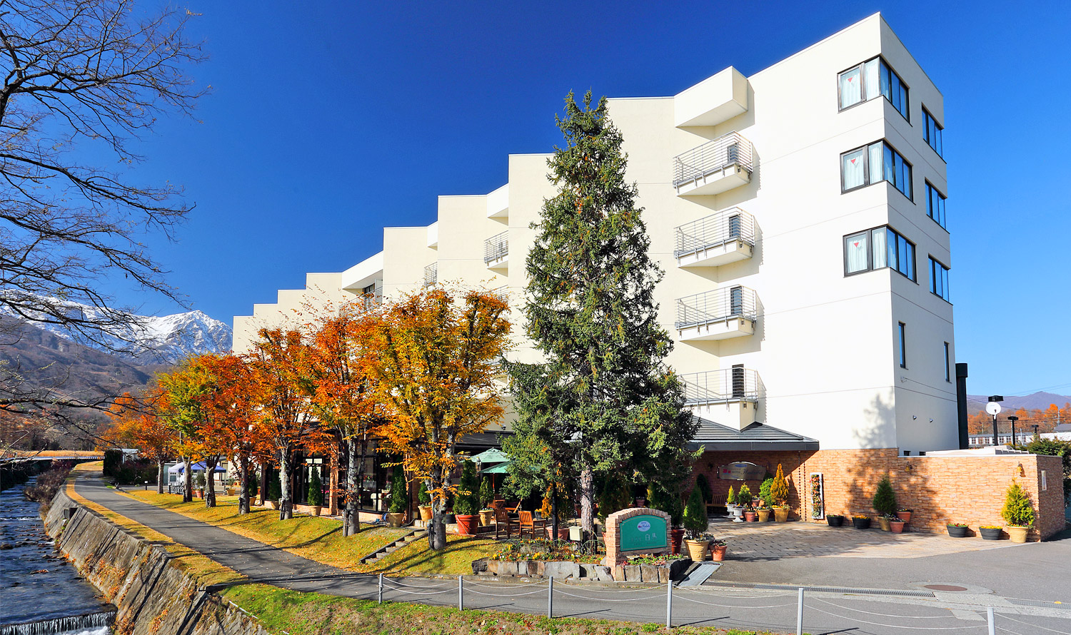ホテル白馬 — 長野県白馬村北城・大楢川沿い · 北アルプスを背にした全室禁煙のホテル外観