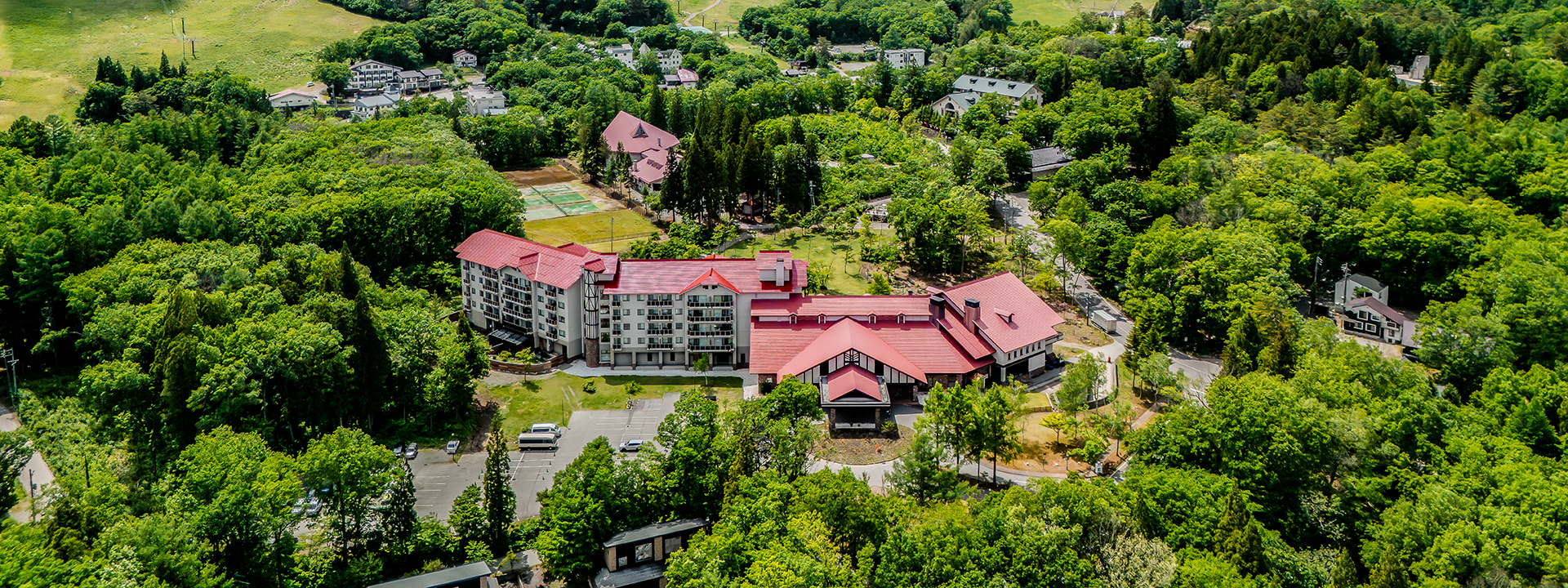 白馬東急ホテル — 長野県白馬村和田野の森 · カラマツ林に囲まれた夏の全景、102室の山岳リゾートホテル