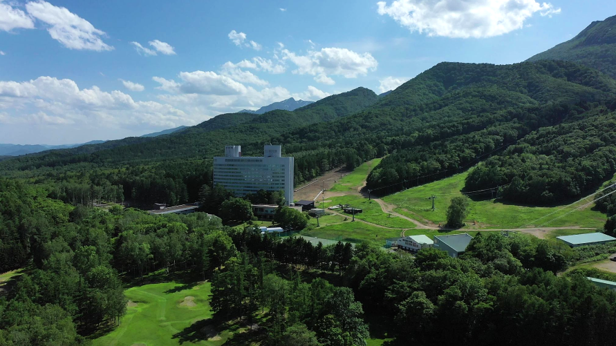新富良野プリンスホテル — 北海道富良野市 · 富良野スキー場のゲレンデに隣接して森の中に建つホテル棟（夏の空撮）