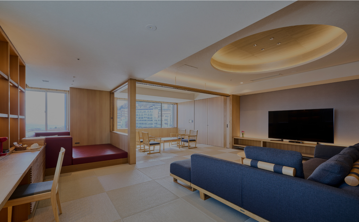 伊香保温泉 ホテル木暮 — 群馬県渋川市 · 畳リビングとソファを備えた広い和洋室、奥に椅子席の広縁が続く