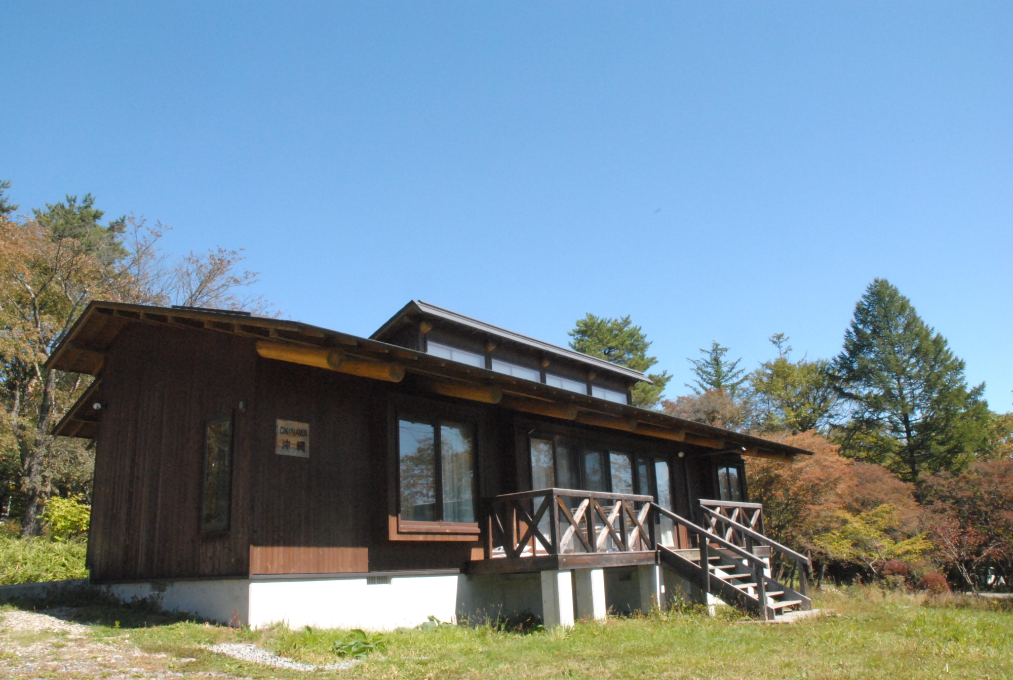 清泉寮 ホテル&コテージ — 山梨県北杜市清里 · 芝地に建つ木造の一戸建てコテージとウッドデッキ