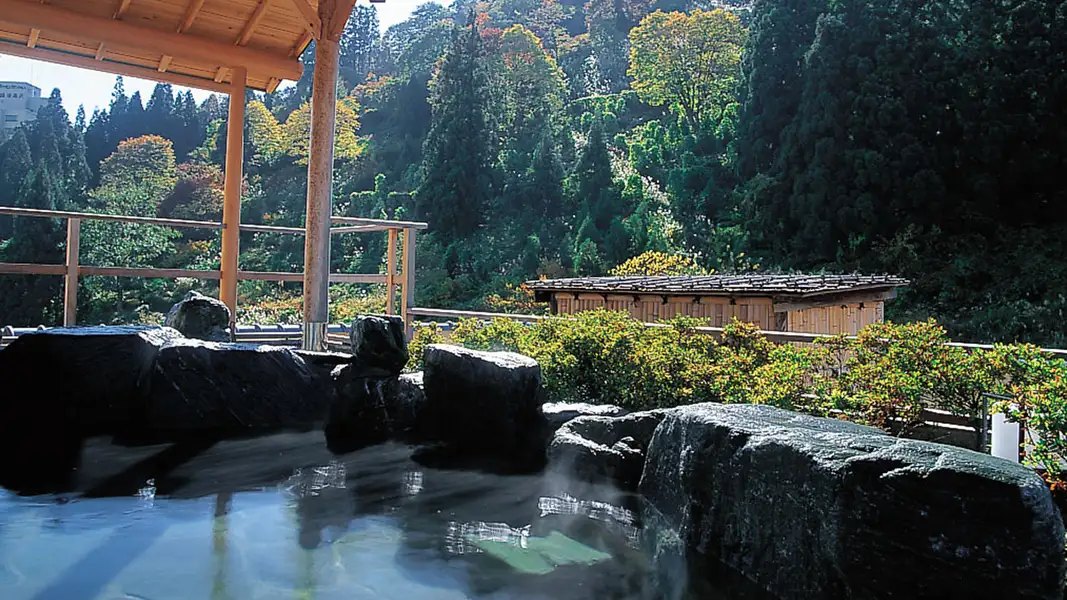 ホテル双葉 — 新潟県湯沢町・越後湯沢温泉 · 岩組みの露天風呂と色づく木々