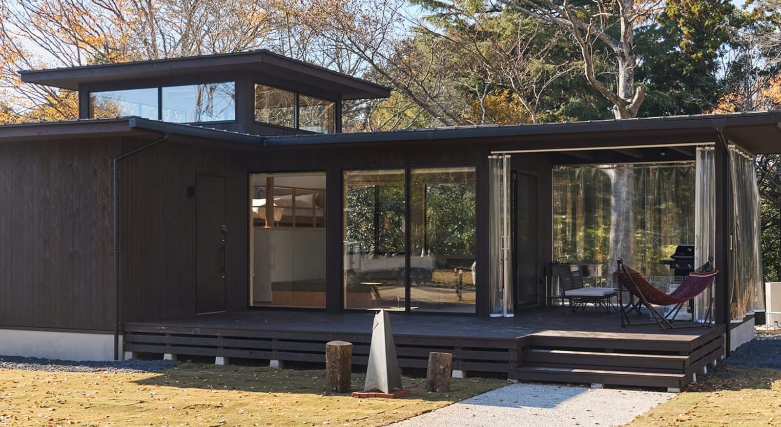 THE BOTANICAL RESORT 林音 — 茨城県那珂市 · 大きな窓とハンモック付きデッキを備えた平屋のコテージ外観