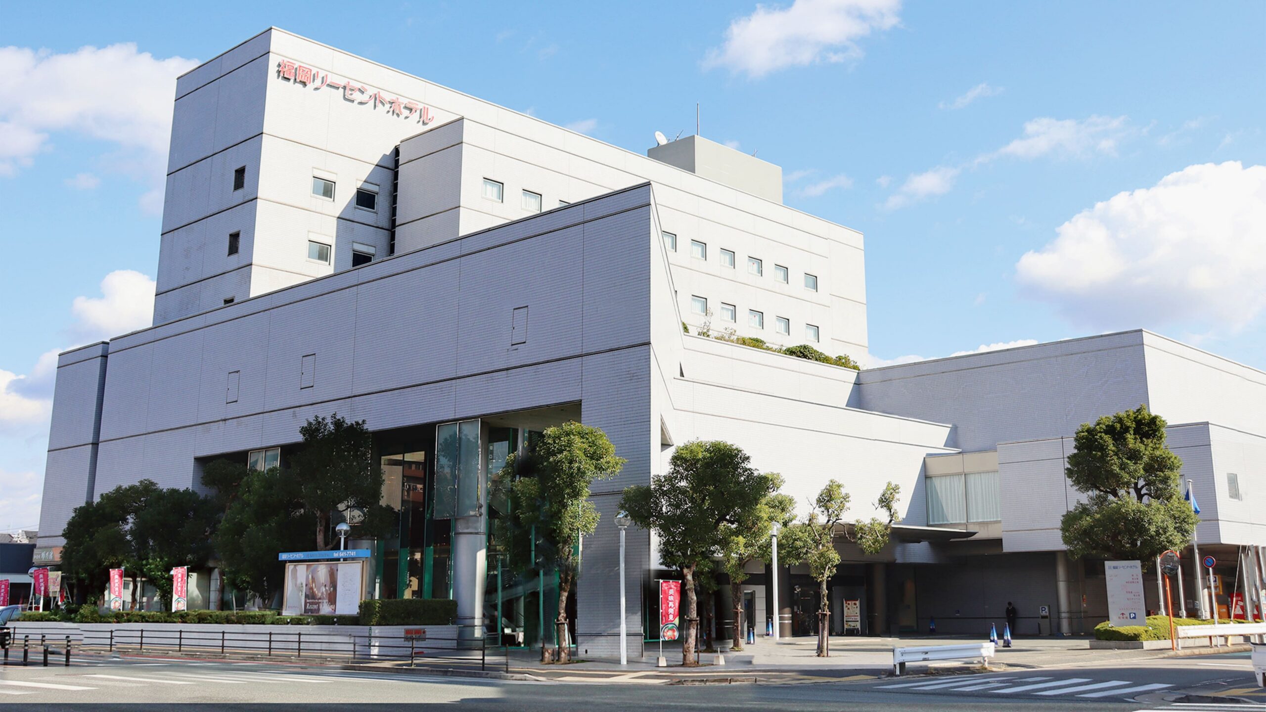 福岡リーセントホテル — 福岡市東区箱崎2丁目 · 白い外壁の建物と植栽のある正面