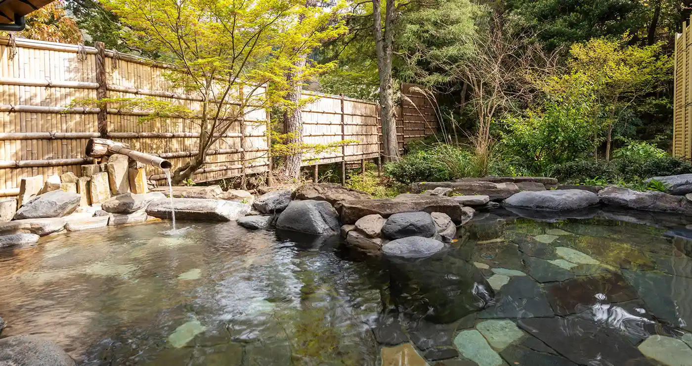 湯回廊 菊屋 — 静岡・修善寺温泉 · 竹垣と木立に囲まれた岩造りの露天風呂、館内に無料の貸切風呂が4か所