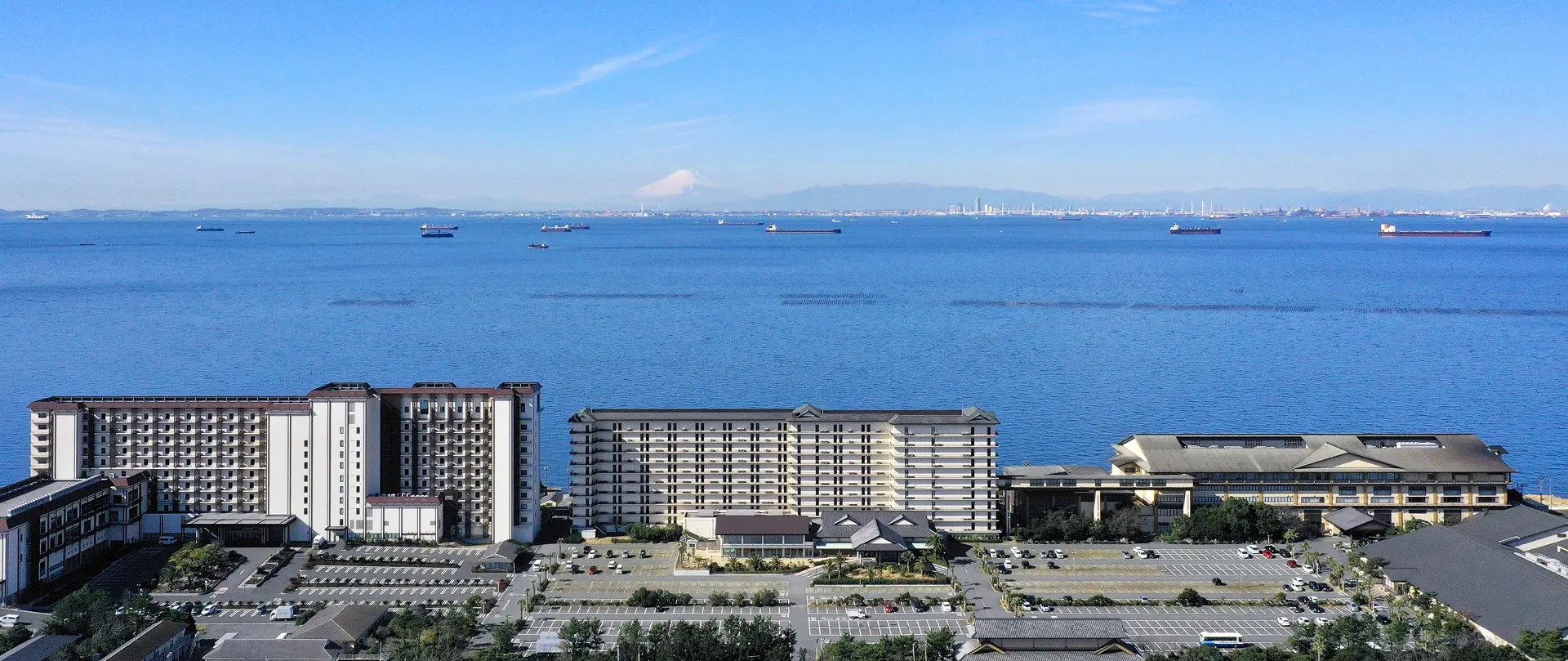 龍宮城スパホテル三日月 — 千葉県木更津市 · 東京湾沿いに並ぶ龍宮亭・富士見亭とスパ棟、奥に富士山